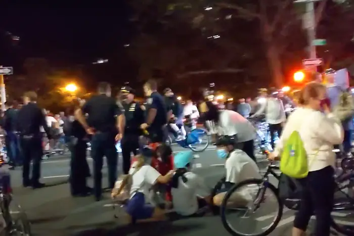 Bike protesters at a protest tending to the injured cyclist.